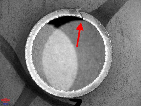 Figure 2: Expanded Edge at the end of a Hole Expansion Test performed using a conical punch. The arrow points to the through-thickness crack that ended the test.E-2